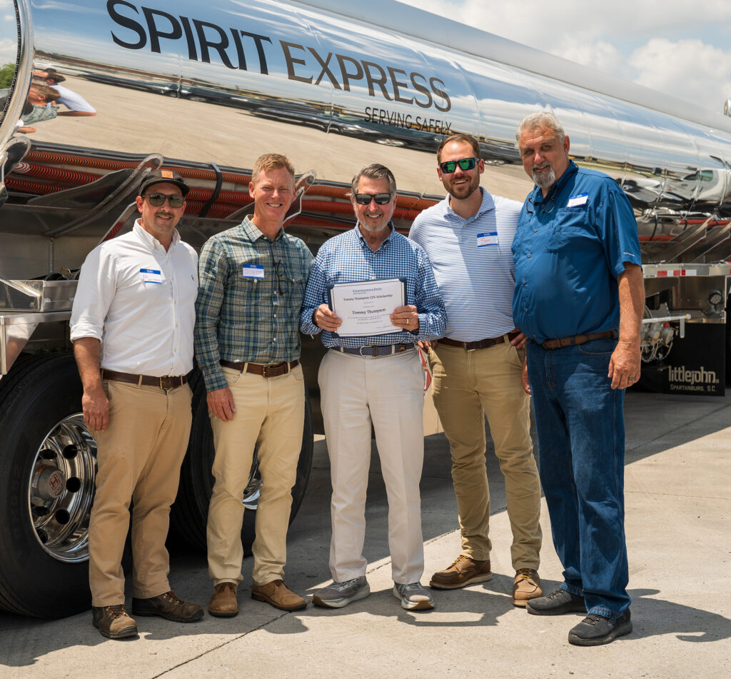 Five men standing in front of tanker truck with certificate